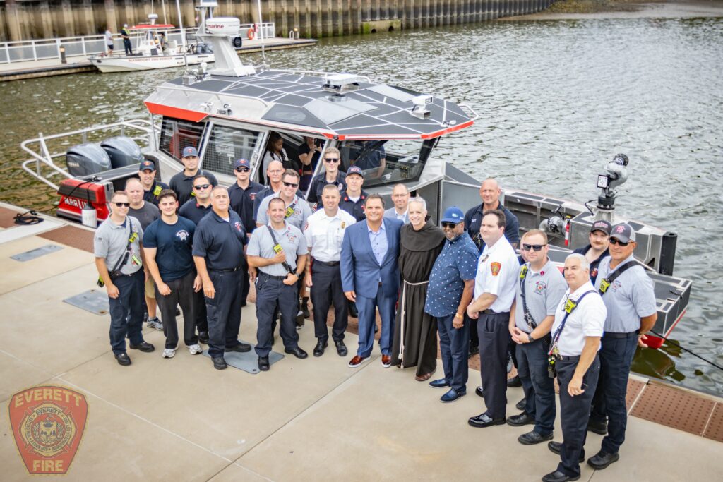 Everett Firefighters posing in front of a boat